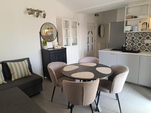 a kitchen and a living room with a table and chairs at Sun-up in Rogoznica