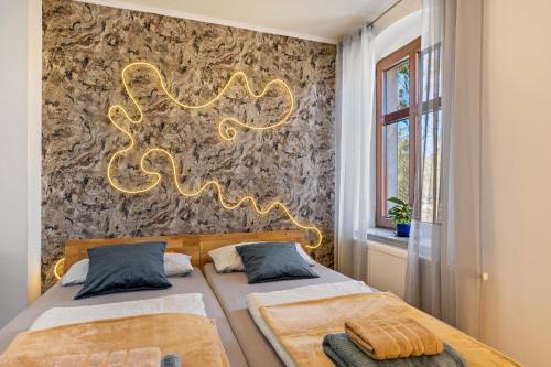 two beds in a bedroom with a gold decoration on the wall at Kleine Ferienwohnung mit Garten in Klosterheide