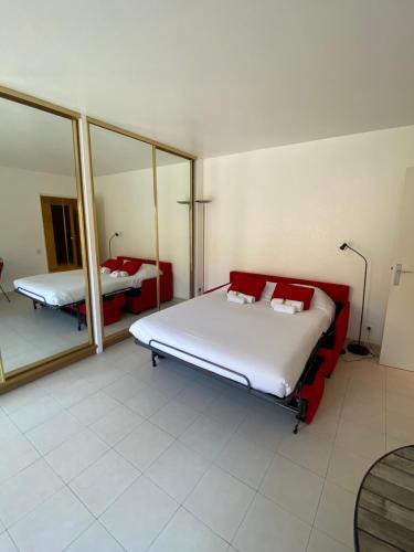 une chambre avec deux lits et un miroir dans l'établissement Studio à deux pas du Palais des Festivals, à Cannes