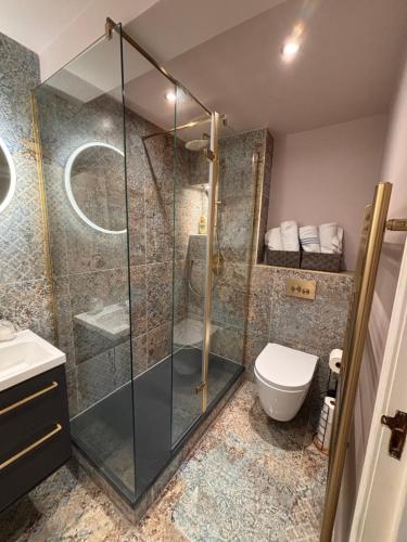 a bathroom with a glass shower and a toilet at The Shore Modern Edinburgh 2 Bedroom Apartment in Edinburgh