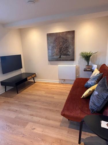 a living room with a couch and a tv at The Shore Modern Edinburgh 2 Bedroom Apartment in Edinburgh
