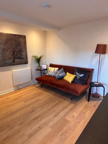 a living room with a couch with pillows on it at The Shore Modern Edinburgh 2 Bedroom Apartment in Edinburgh