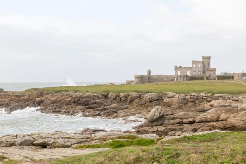 un château sur une falaise à côté de l'océan dans l'établissement appartement vilvic, à Trégunc