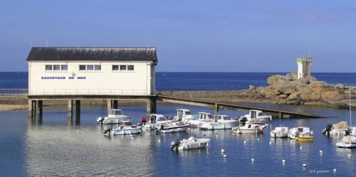 un groupe de bateaux dans l'eau près d'un bâtiment dans l'établissement appartement vilvic, à Trégunc