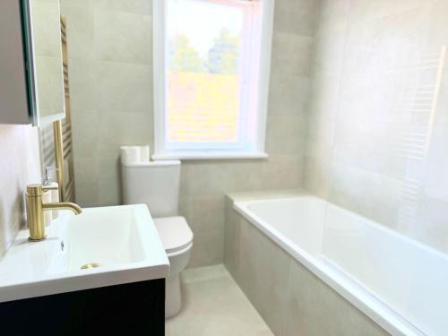 a bathroom with a sink and a tub and a toilet at Entire Cosy Flat in Radlett - 3 Bedrooms -5 Beds - Sleeps 8 - Fast Train access into central London in Radlett