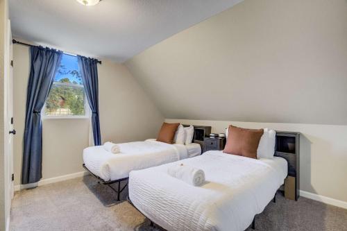 two beds in a room with a window at Mountain Villa Scenic Views Hot Tub & Fire Pit in Cascade-Chipita Park