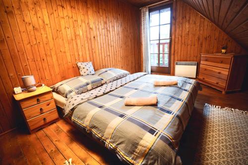 a bedroom with a bed and a wooden wall at Drevenica Tatry No 1 in Liptovský Mikuláš
