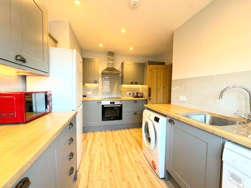a kitchen with a washer and dryer in it at Entire Cosy Flat in Radlett - 3 Bedrooms -5 Beds - Sleeps 8 - Fast Train access into central London in Radlett