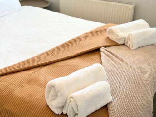 a bed with two towels on the side of it at Entire Cosy Flat in Radlett - 3 Bedrooms -5 Beds - Sleeps 8 - Fast Train access into central London in Radlett