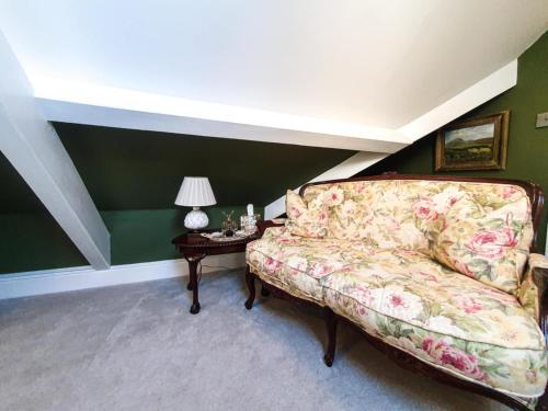 a living room with a couch and a table at Plas Dinas Country House in Caernarfon