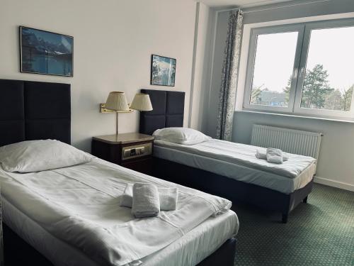 a hotel room with two beds and a window at Hotel Bella Vista Warszawa in Warsaw