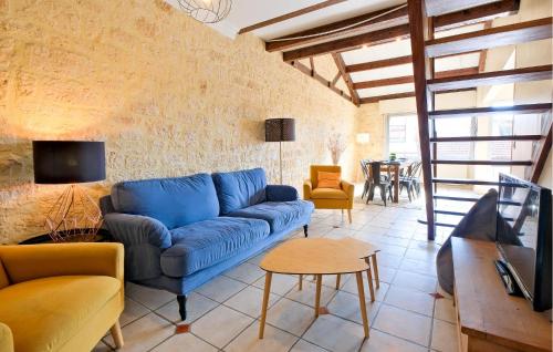 a living room with a blue couch and a table at 4 Bedroom Cozy Apartment In Périgueux in Périgueux