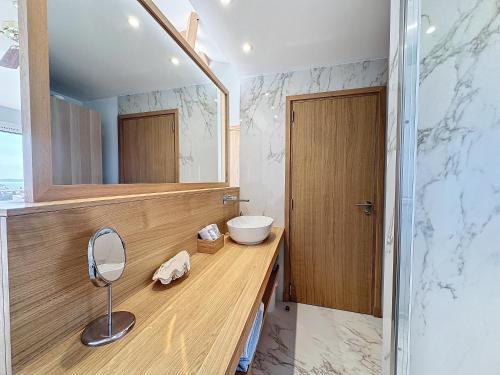 une salle de bain avec un lavabo et un miroir dans l'établissement Vue époustouflante sur la mer, au Lavandou