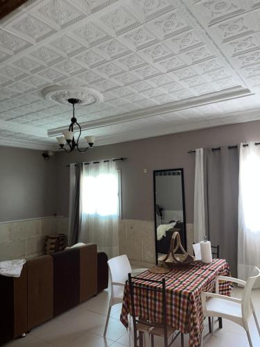 a living room with a coffered ceiling and a table and chairs at Chez saly in Saint-Louis