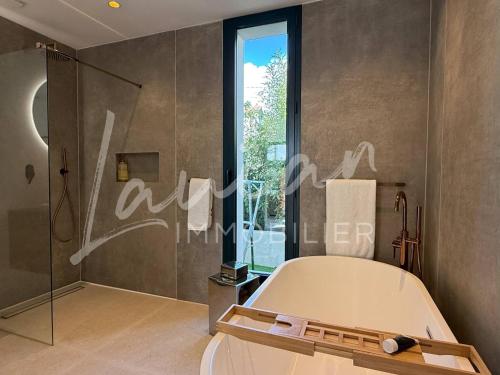 La salle de bains est pourvue d'une douche, d'un lit et d'une fenêtre. dans l'établissement Villa Oasis - Élégance et situation idéale, à Biarritz