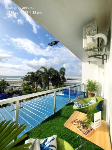 a balcony with a view of a pool and the ocean at The beach house, Baroro in Bacnotan