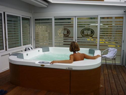 una mujer sentada en una bañera en una habitación en Hotel Villa San Michele, en Carmignano
