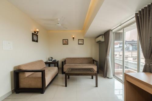 a living room with a couch and a table at Hotel Shoolin Grand in Mangalore
