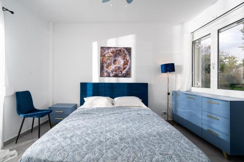 a bedroom with a blue bed and a blue dresser at The Greek Getaway in Lóngos