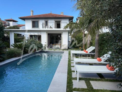 une maison avec une piscine devant une maison dans l'établissement Villa Oasis - Élégance et situation idéale, à Biarritz