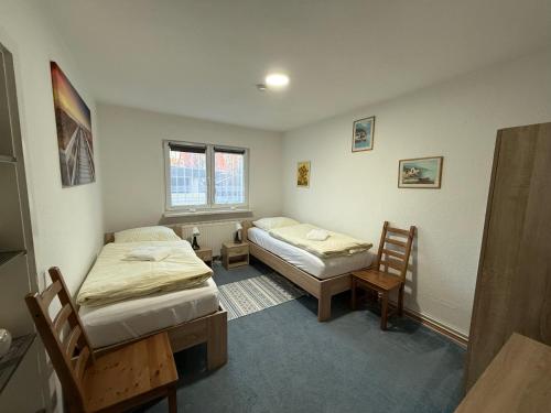 a room with two beds and two chairs in it at Gästehaus mit Garten in Blankenfelde