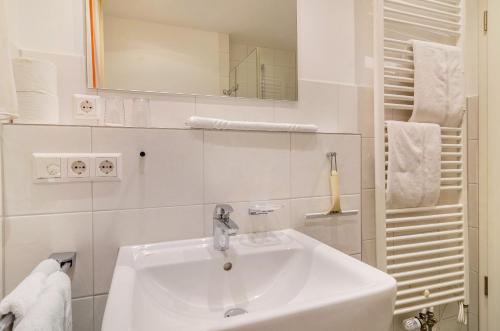 a white bathroom with a sink and a mirror at Gästehaus D i c k r e i t e r in Immenstaad am Bodensee