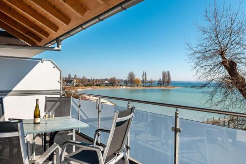 a table and chairs on a balcony with a view of the water at Gästehaus D i c k r e i t e r in Immenstaad am Bodensee