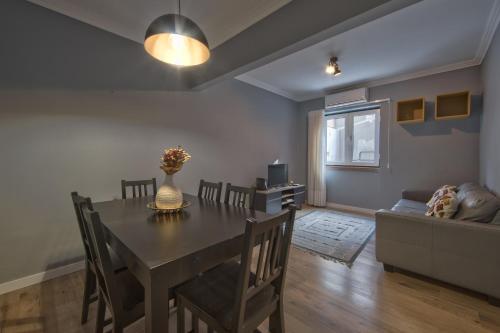 a dining room with a table and a couch at Jamor Terrace by Homing in Cruz Quebrada