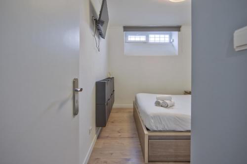 a small bedroom with a bed and a window at Jamor Terrace by Homing in Cruz Quebrada