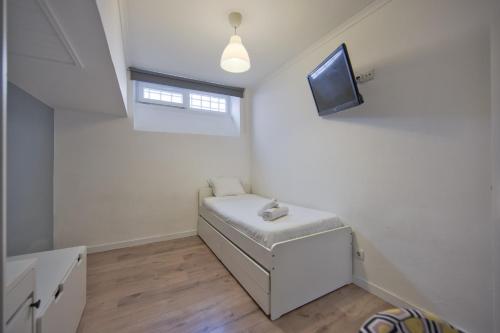 a living room with a couch and a tv at Jamor Terrace by Homing in Cruz Quebrada