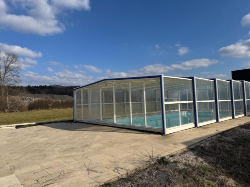 une maison en verre avec une piscine. dans l'établissement Maison 8 personnes 4 Chambres Doubles - Piscine, à Anould