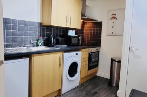 a kitchen with a washing machine and a sink at Beachside Home - Sleeps 5 Garden Parking & Pets in Skegness