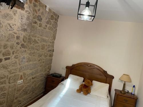 a teddy bear sitting on a bed in a bedroom at Casa de Ferreñas-5 dormitorios in Esteiro