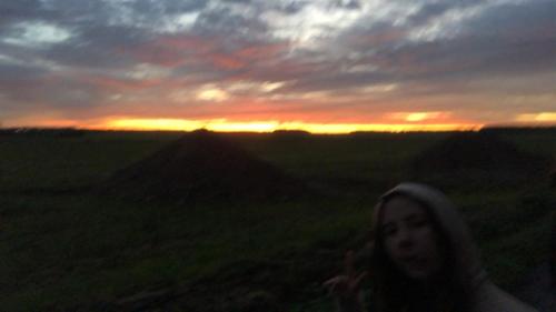 une femme posant dans un champ avec le coucher du soleil en arrière-plan dans l'établissement Maison 5 min de la plage, à Quiberon