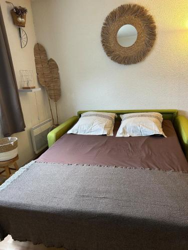 une chambre avec un lit avec un miroir au mur dans l'établissement Studio - Calais la Plage, à Calais