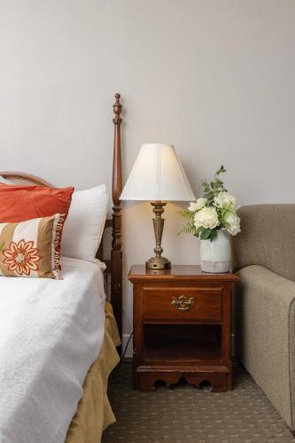 a bed and a lamp on a table next to a couch at Brandywine River Hotel in Chadds Ford