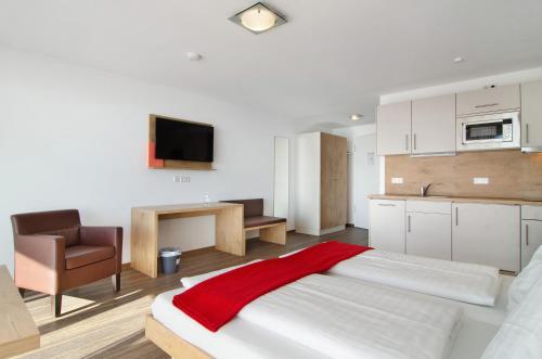a bedroom with a large bed with a red blanket on it at Gästehaus D i c k r e i t e r in Immenstaad am Bodensee
