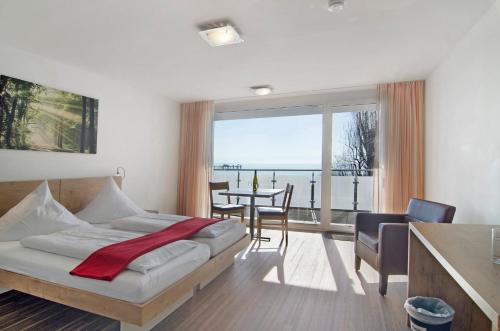 a bedroom with a bed and a table with chairs at Gästehaus D i c k r e i t e r in Immenstaad am Bodensee