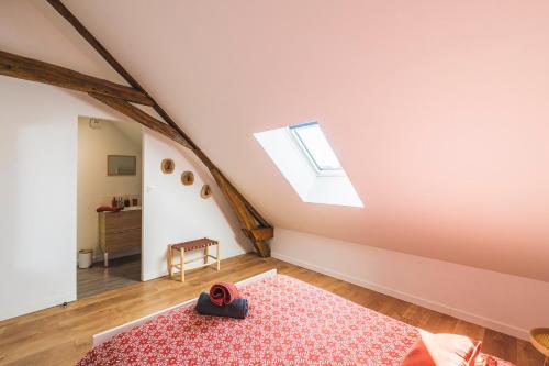 Cette chambre mansardée dispose d'un tapis rouge et d'une lucarne. dans l'établissement La CASA DEM, Cormontreuil Reims, madamedemconciergerie, à Cormontreuil