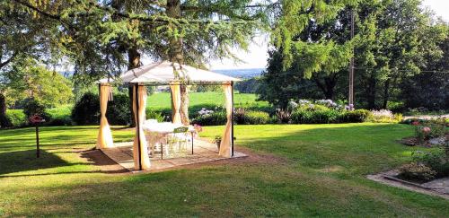 a gazebo with a chair in a yard at Maison de campagne Talara in Locqueltas