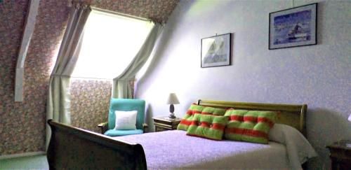 a bedroom with a bed and a blue chair at Maison de campagne Talara in Locqueltas