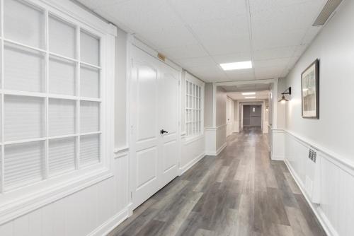 an empty hallway with white walls and windows at Brandywine River Hotel in Chadds Ford