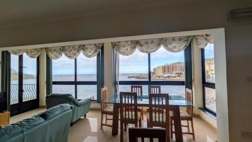 マルサルフォーンにあるSeaside Apartment Marsalfornのテーブルと椅子と窓のあるリビングルーム
