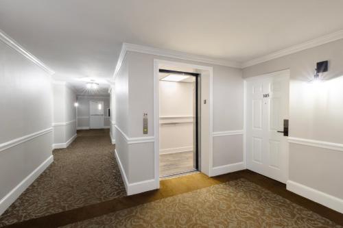 a hallway with white walls and an open door at Brandywine River Hotel in Chadds Ford