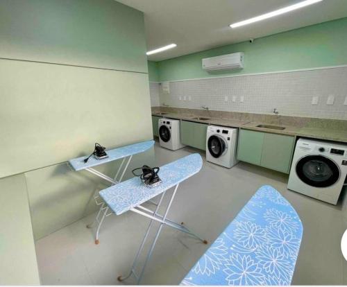 a laundry room with two washing machines and a chair at New Studios by VLV Stays in Salvador