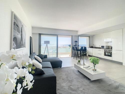un salon avec un canapé bleu et une cuisine dans l'établissement Appartement Vue mer, à Vallauris
