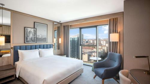 a bedroom with a bed and a chair and a window at Radisson Hotel Istanbul Merter in Istanbul
