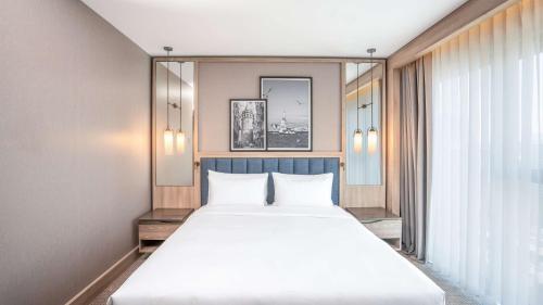 a large white bed in a room with a window at Radisson Hotel Istanbul Merter in Istanbul