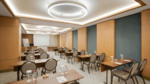a conference room with tables and chairs and a whiteboard at Radisson Hotel Istanbul Merter in Istanbul