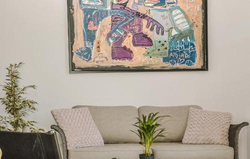 - un canapé dans le salon orné d'une peinture murale dans l'établissement Suite Frênes Avec Piscine, à Gien